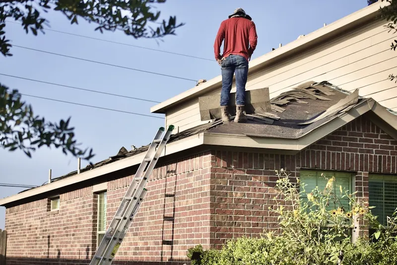 Professional roofer working on a residential roof in Wauregan